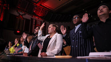 New citizens raising their right hands at a ceremony